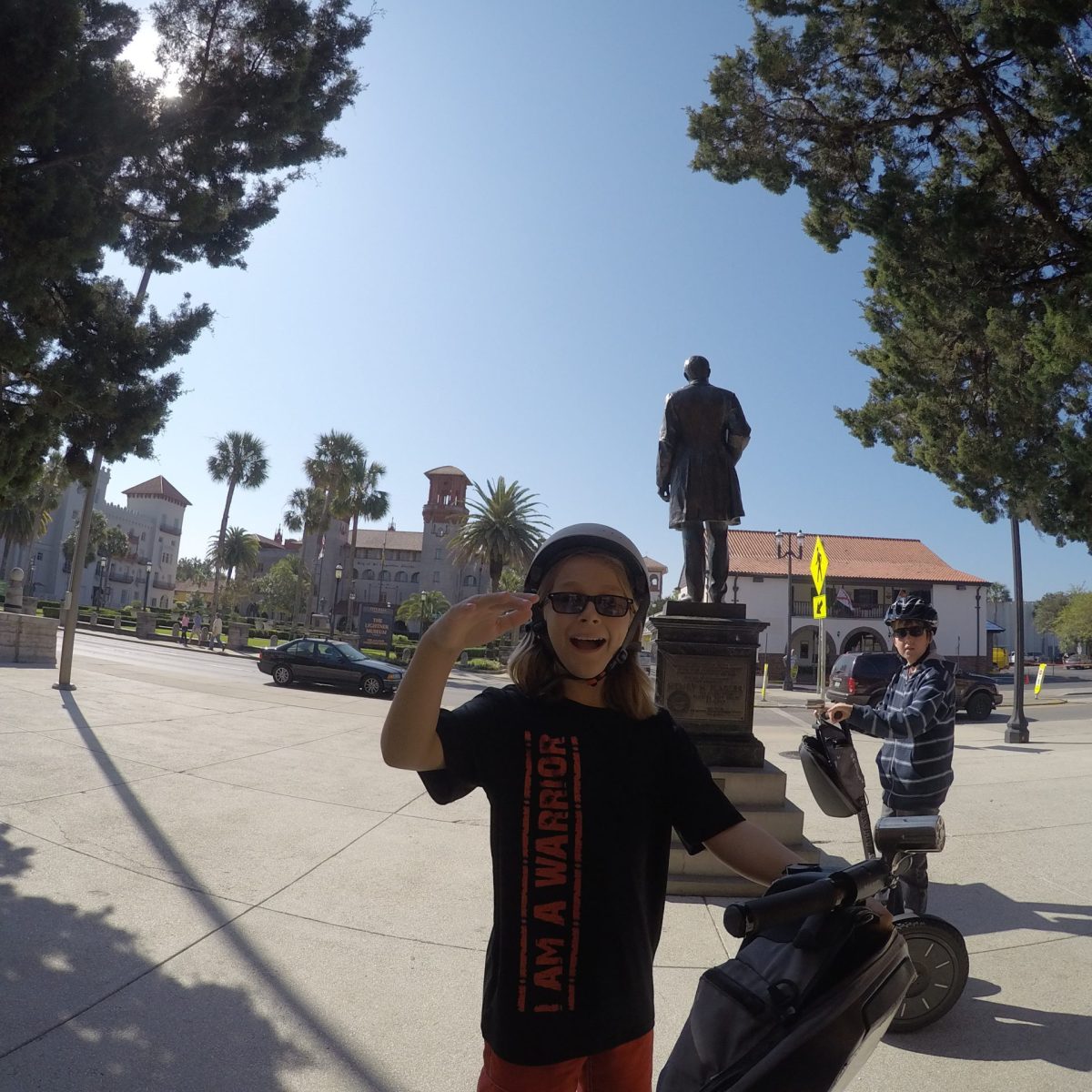 a young boy riding a skateboard up the side of a road