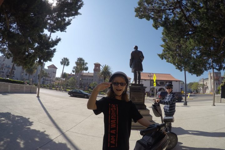 a young boy riding a skateboard up the side of a road